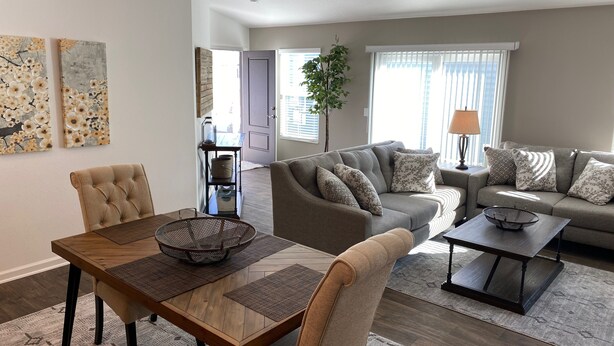 A modern living room with a wooden dining table, a grey sofa, and a ceiling fan. - 356 Hood Pl (Wildwood)