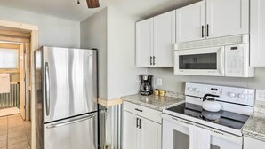 A modern kitchen with stainless steel appliances, white cabinets, and a granite countertop. - Lakefront Retreat w/ Fire Pit & Dock in Castlewood (Castlewood)