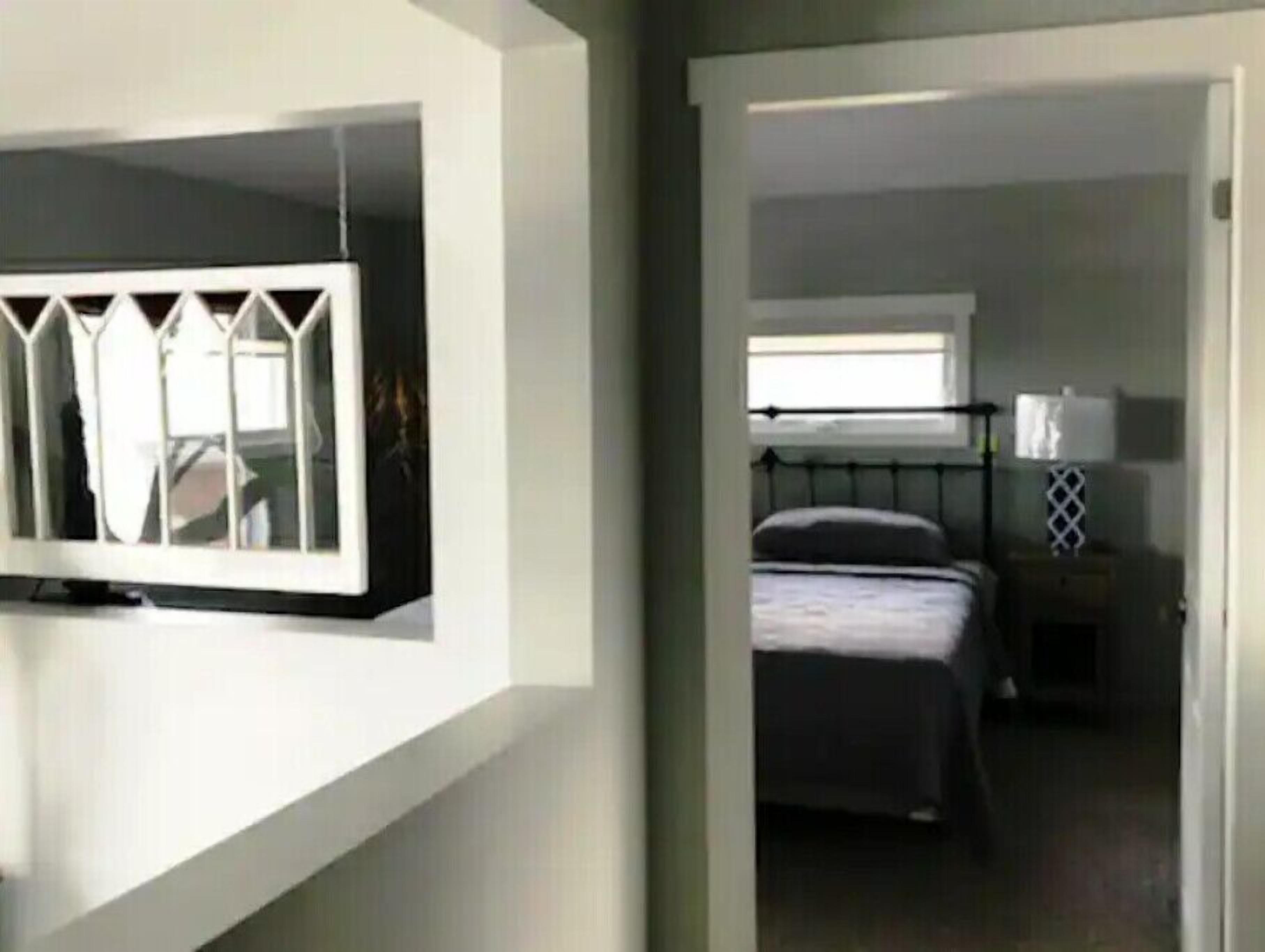A bedroom with a bed, a bedside table, and a window.
