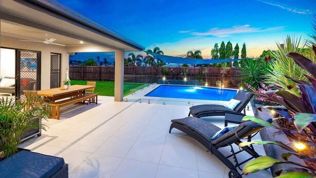A backyard with a swimming pool, outdoor furniture, and a covered patio area. - Tropical Dreams—Spacious Retreat with Private Pool (Smithfield)