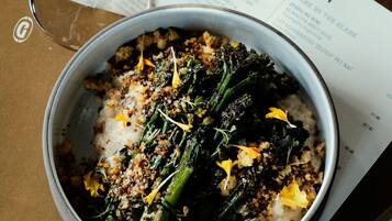 A bowl of food with a menu in the background.