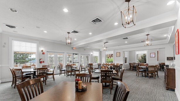 A spacious dining area with multiple tables and chairs, large windows, and ceiling lights. - Pools~Screened-In Deck~Dog-Friendly~2 King Beds (Branson)