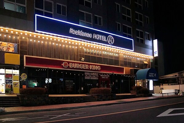 Un edificio con un letrero que indica 'Residence Hotel' y un restaurante 'Burger King'.