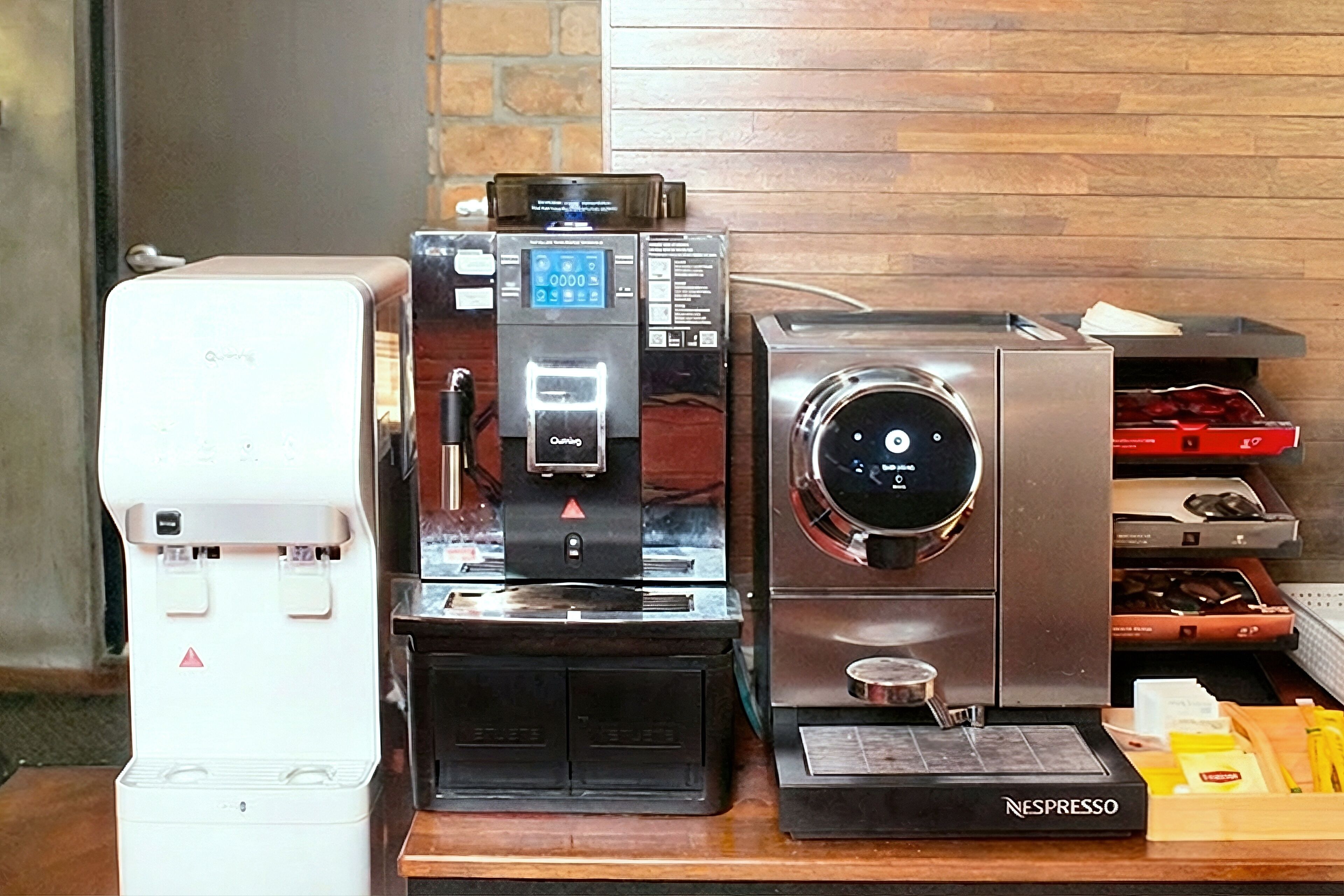 Uma estação de café com cafeteira, máquina de café e máquina Nespresso.