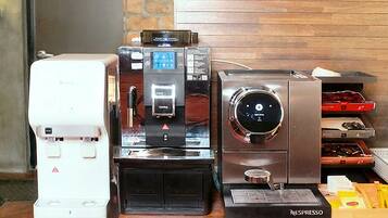 Una estación de café con una cafetera, una máquina de café y una máquina Nespresso.