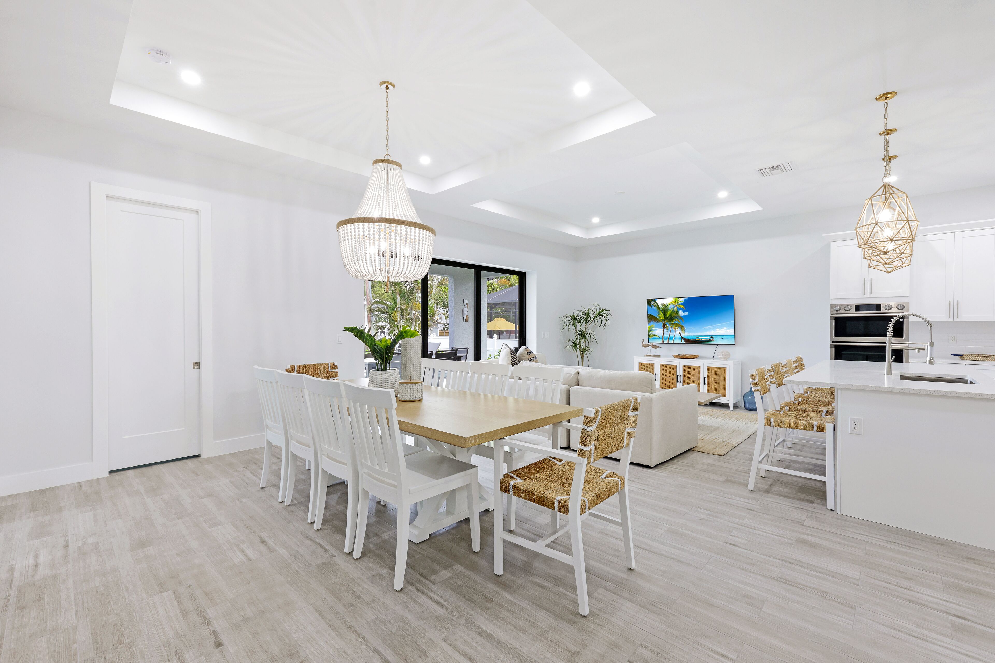 Una cocina moderna con armarios blancos, una isla central e iluminación colgante.