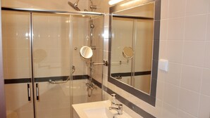 A modern bathroom with a glass-enclosed shower, a vanity with a mirror, and a sink. - Quiet, Comfortable & Amazing Location (Óbidos)