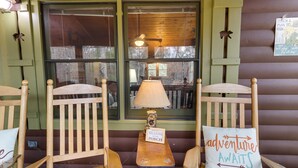 A cozy porch with wooden chairs, a small table, and a lamp. A sign on the table reads "Relaxing on the Porch." - Private Hot Tub! ‘Cherry Beary Den’ in Blue Ridge (Blue Ridge)