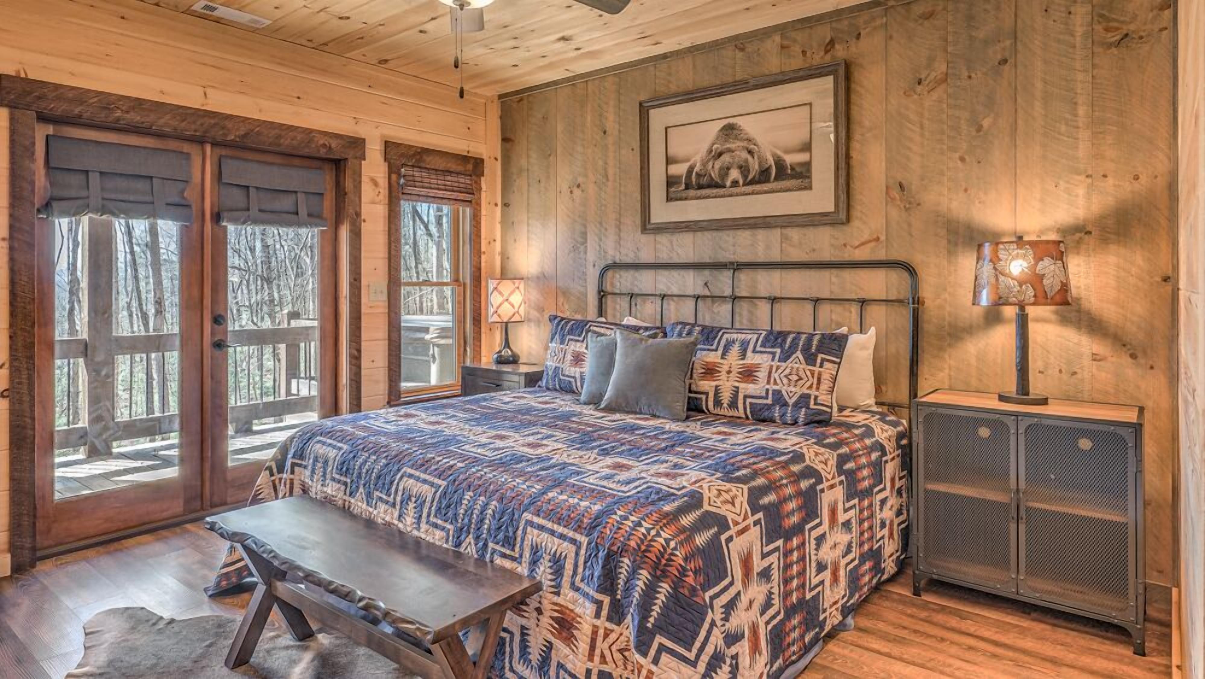 A bedroom with a large bed, a bench, a heater, and a framed picture on the wall.