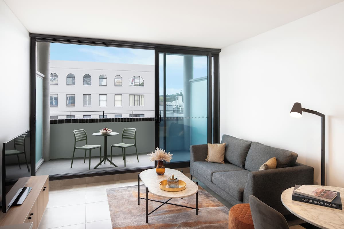 Ein modernes Wohnzimmer mit einer Couch, einem Couchtisch und einem Essbereich mit Stühlen.