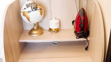 Un bureau compact en bois, sur lequel on peut voir un globe terrestre, un petit récipient blanc et un objet rouge, le tout posé sur une étagère.