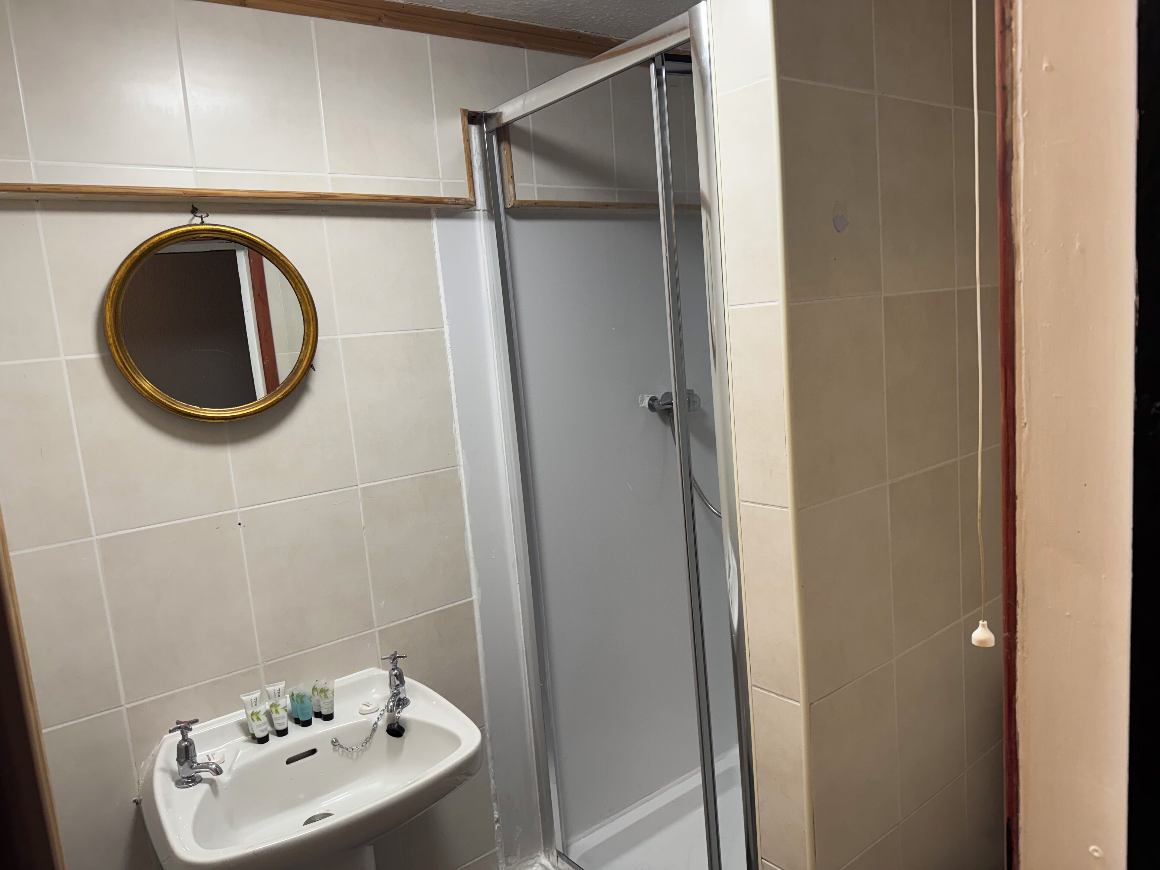 A bathroom with a white sink, a mirror, and a glass shower enclosure.