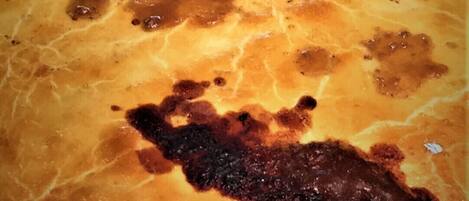 A large, round, golden-brown baked dish with a slightly charred top.