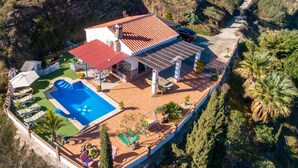Una casa amb piscina, terrassa i panells solars.