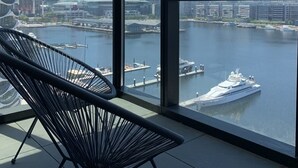 A modern room with large windows overlooking a marina and city skyline.