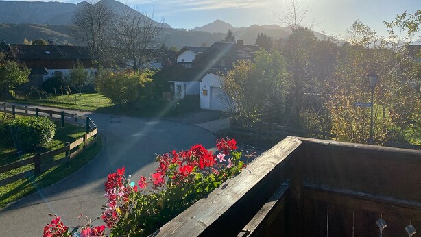 A residential area with houses, a road, and a mountain range in the background.