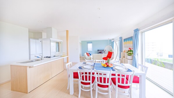 A modern kitchen with white cabinets and a dining area with a table set for four.