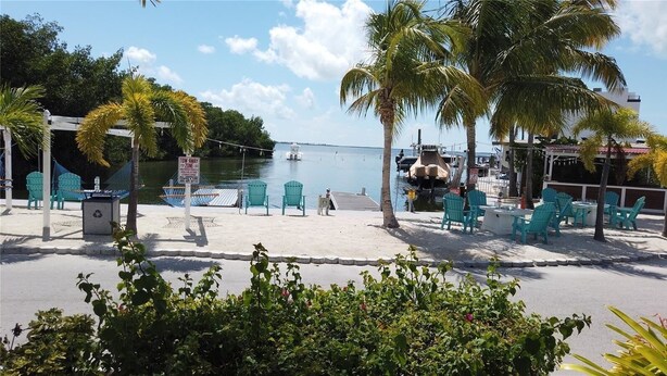 A beachside area with turquoise chairs, a hammock, and a sign indicating a tow-away zone. - Relax in Calusa Key Largo (Key Largo)