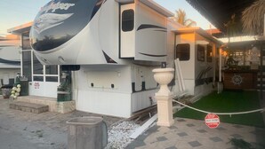 A large RV with a curved front, a white exterior, and a logo on the side. - Relax in Calusa Key Largo (Key Largo)