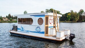 A houseboat with a deck, a ladder, and a Suzuki outboard motor. - Fully-Equipped Boat 'Lisa' with Terraces (Priepert)