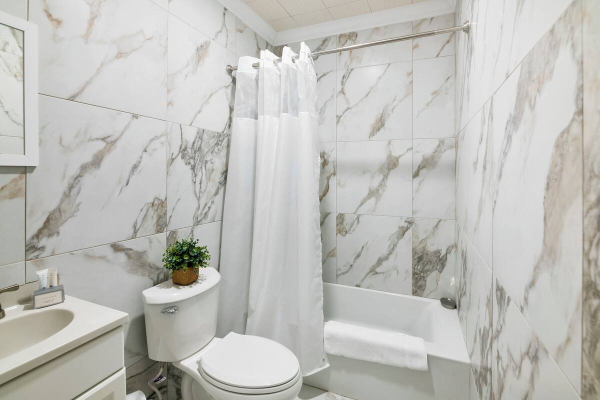 A bathroom with a toilet, sink, and bathtub, all in white.