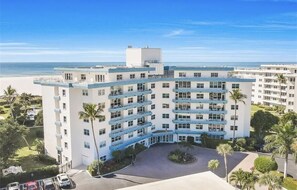 A multi-story hotel with a central courtyard, balconies, and a view of the beach. - Sunset House - Beautiful Marco Island 2/2 Beach Front Condo (Marco Island)