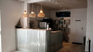 A modern kitchen with a central island, pendant lighting, and a visible laundry area. - Cozy Crner, home away from home, mere 100m away from pristine beaches (Langebaan)