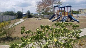 A playground with slides and a climbing structure. - Jacaranda Vacation Home (Spanish Town)