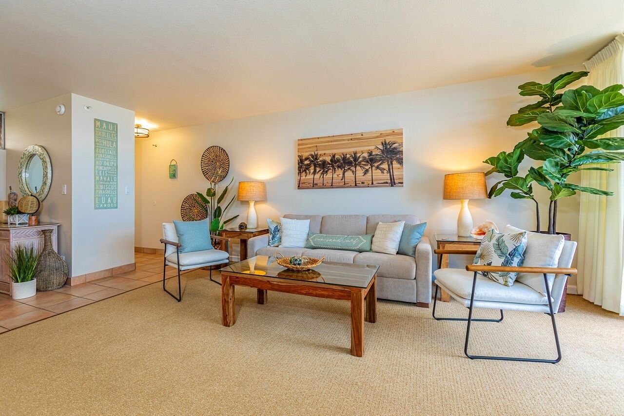 A living room with a sofa, two armchairs, a coffee table, and a wall-mounted lamp.
