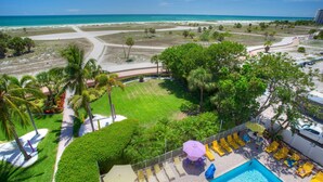 Un complexe hôtelier doté d’une piscine, de chaises longues et offrant une vue sur la plage.