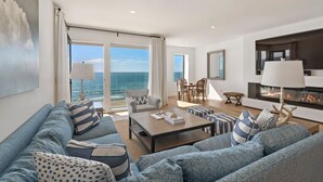 Ein modernes Wohnzimmer mit einem großen Sofa, einem Couchtisch und einem Kamin.