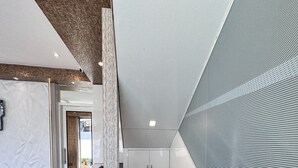A modern kitchen with a white countertop, a kettle, a fire extinguisher, and a window with a view. - Hotel Orchid Inn - Andheri (Mumbai)