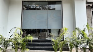 The exterior of Hotel Orchid Inn with a sign in both English and Hindi, large glass doors, and steps leading up to the entrance. - Hotel Orchid Inn - Andheri (Mumbai)