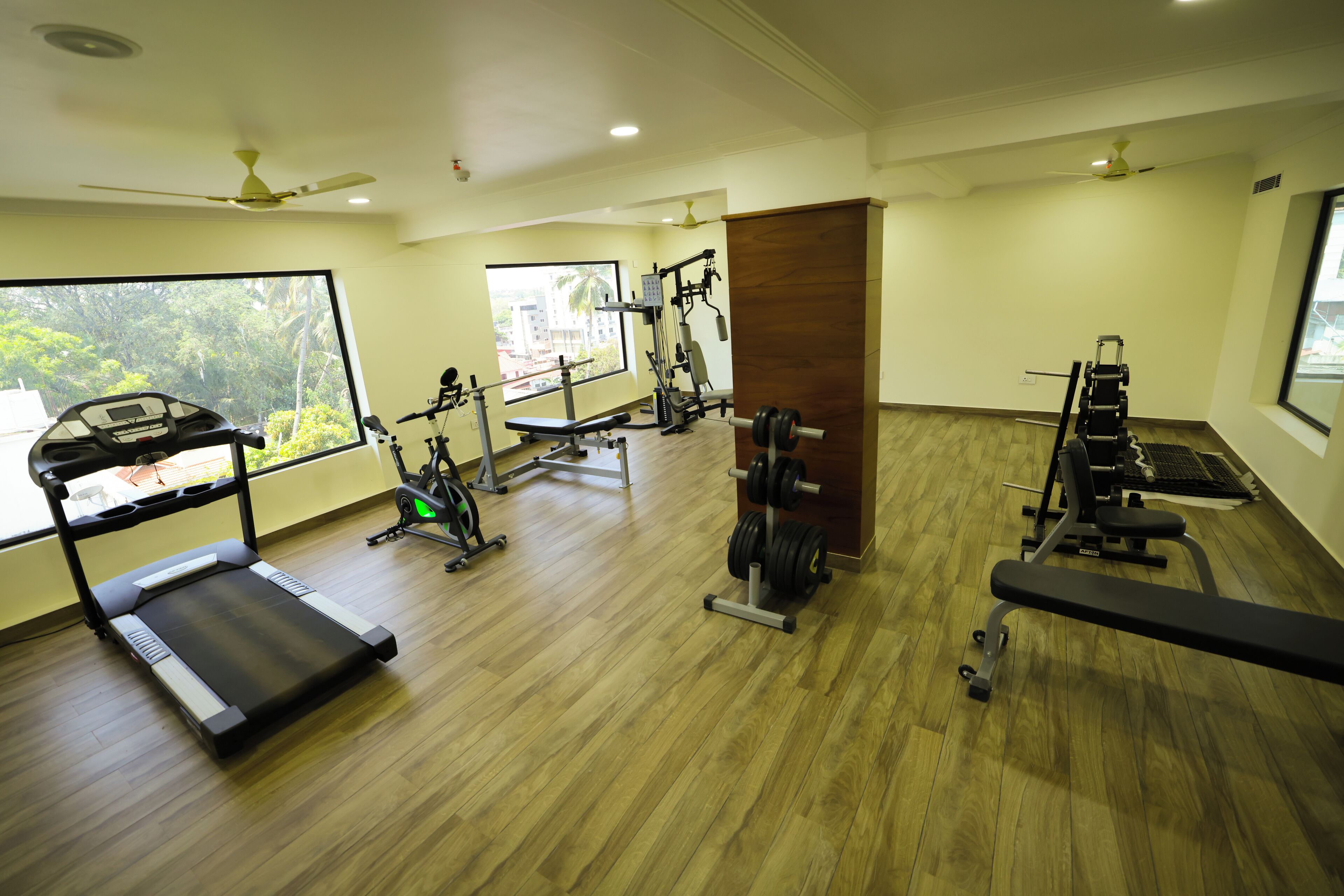 A gym with a treadmill, weight machines, and a bench.