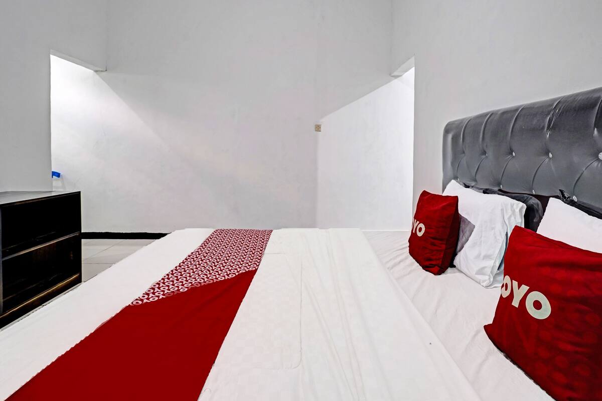 Ein Schlafzimmer mit einem Bett, einem Kopfteil und einer Kommode.