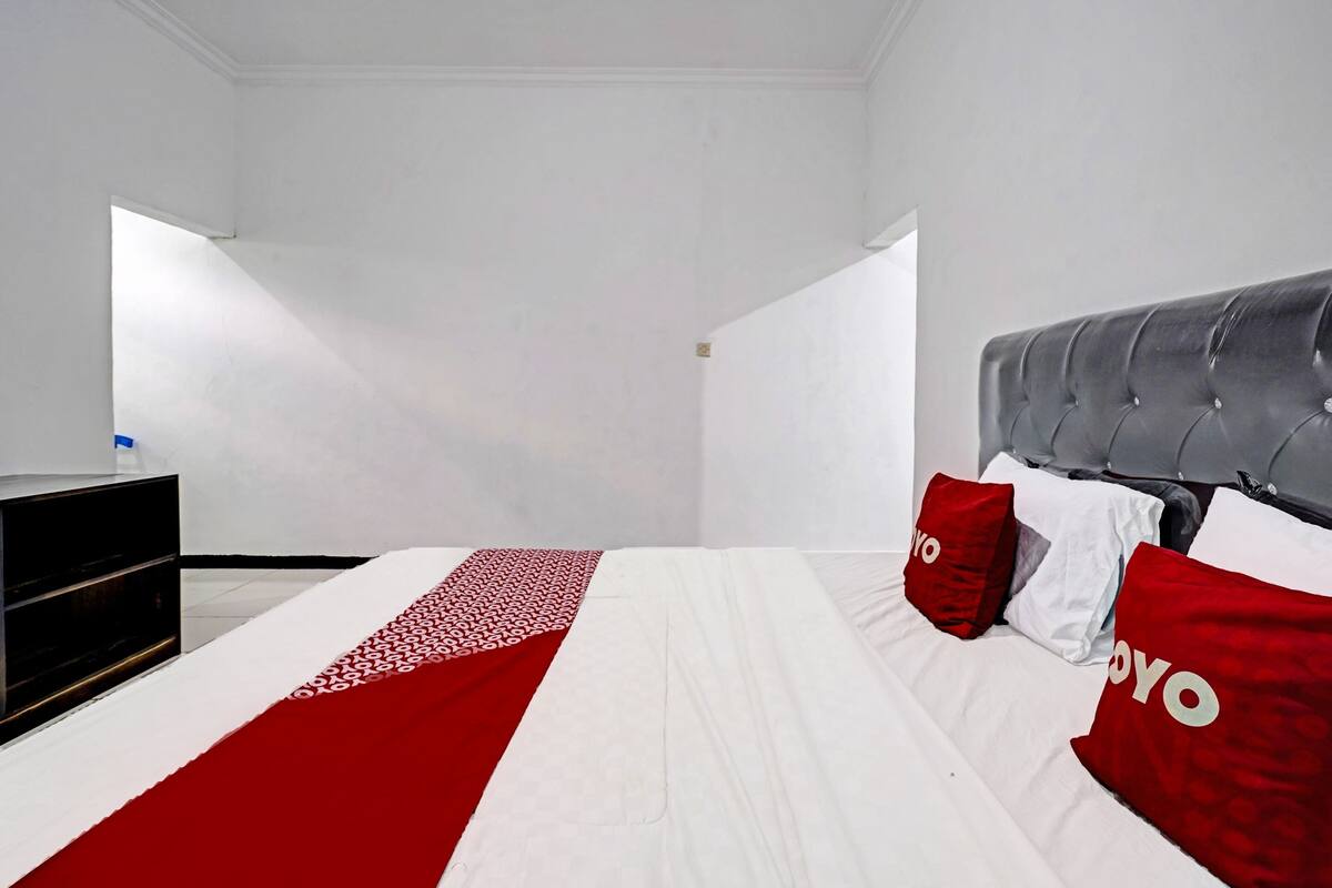 Ein Hotelzimmer mit einem Bett, einem Schminktisch und einem Fenster.