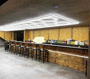 Relax in our stylish bar area, featuring a hexagonal ceiling and sleek bar counter.