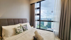 A bedroom with a large window, a bed with white linens, and two pillows with nature-themed designs. - The Robertson Residence (Kuala Lumpur)