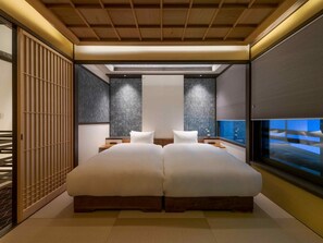 A modern bedroom with a large bed, a view of the city, and a sliding shoji screen. - Marikoji Machiya House (Kyoto)