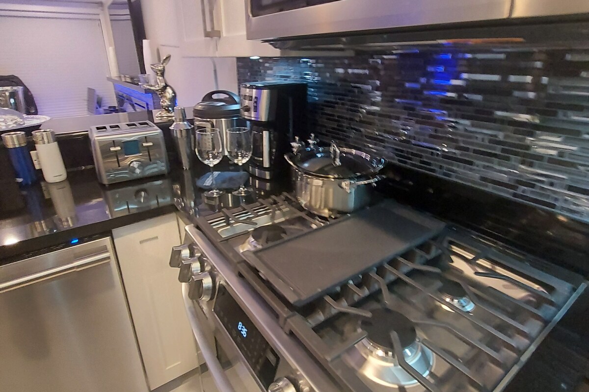 A modern kitchen with stainless steel appliances, a built-in oven, and a coffee maker.