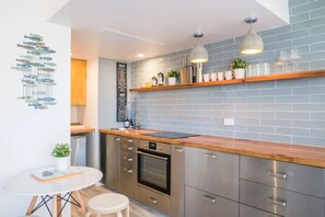 Enjoy cooking in this well-equipped kitchen with a stainless steel oven, sink, and ample storage.
