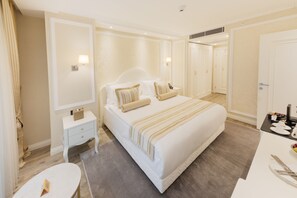Habitación de hotel con una cama grande, una mesita de noche, una silla y un escritorio con una silla.