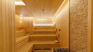 Una sauna con bancos de madera y una pared de piedra.