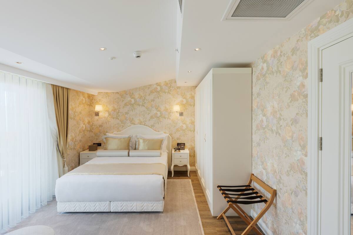 A bedroom with a bed, bedside tables, a wardrobe, and a chair.