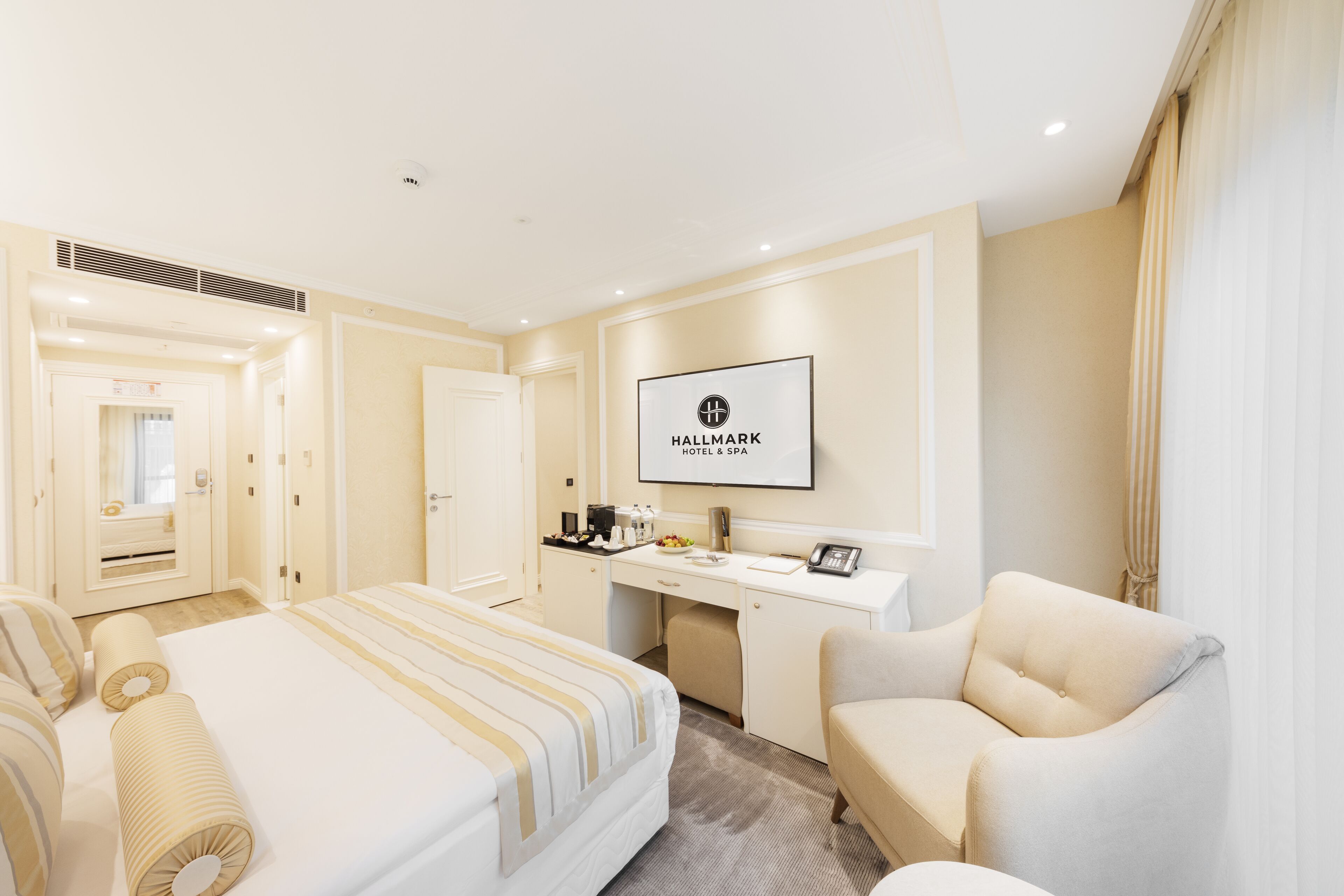 Une chambre d’hôtel avec un lit, un bureau, une chaise et un panneau encadré accroché au mur.