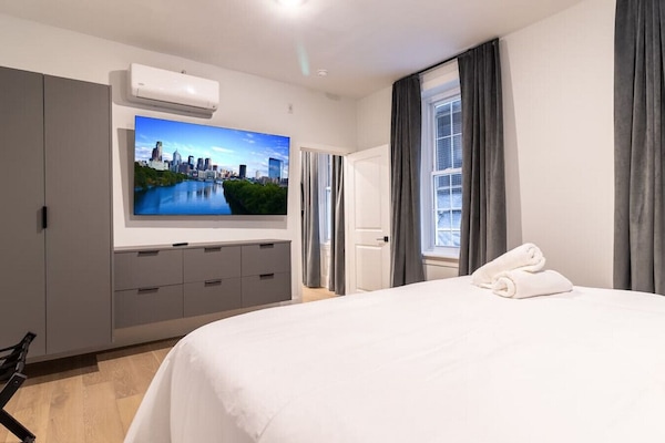 Bright modern bedroom with a plush queen bed and flat-screen TV