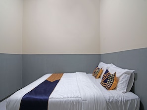 Un lit simple avec une literie blanche, un coussin décoratif bleu et jaune, et un plaid bleu et jaune.