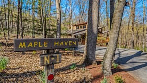 Un panneau indicateur en bois portant les inscriptions « Maple Haven » et « N-1 », indiquant un lieu.