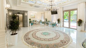 A spacious lobby with a large, ornate rug, a grand chandelier, and a modern seating area. - Royal Hotel Samarkand (Samarkand)