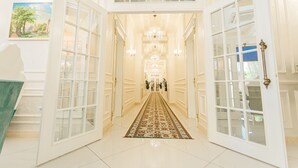 A hallway with a patterned carpet, double doors, and a chandelier. - Royal Hotel Samarkand (Samarkand)